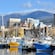Sailboats docked in the harbor of Hobart Bay, Alaska with city buildings and a mountainous landscape